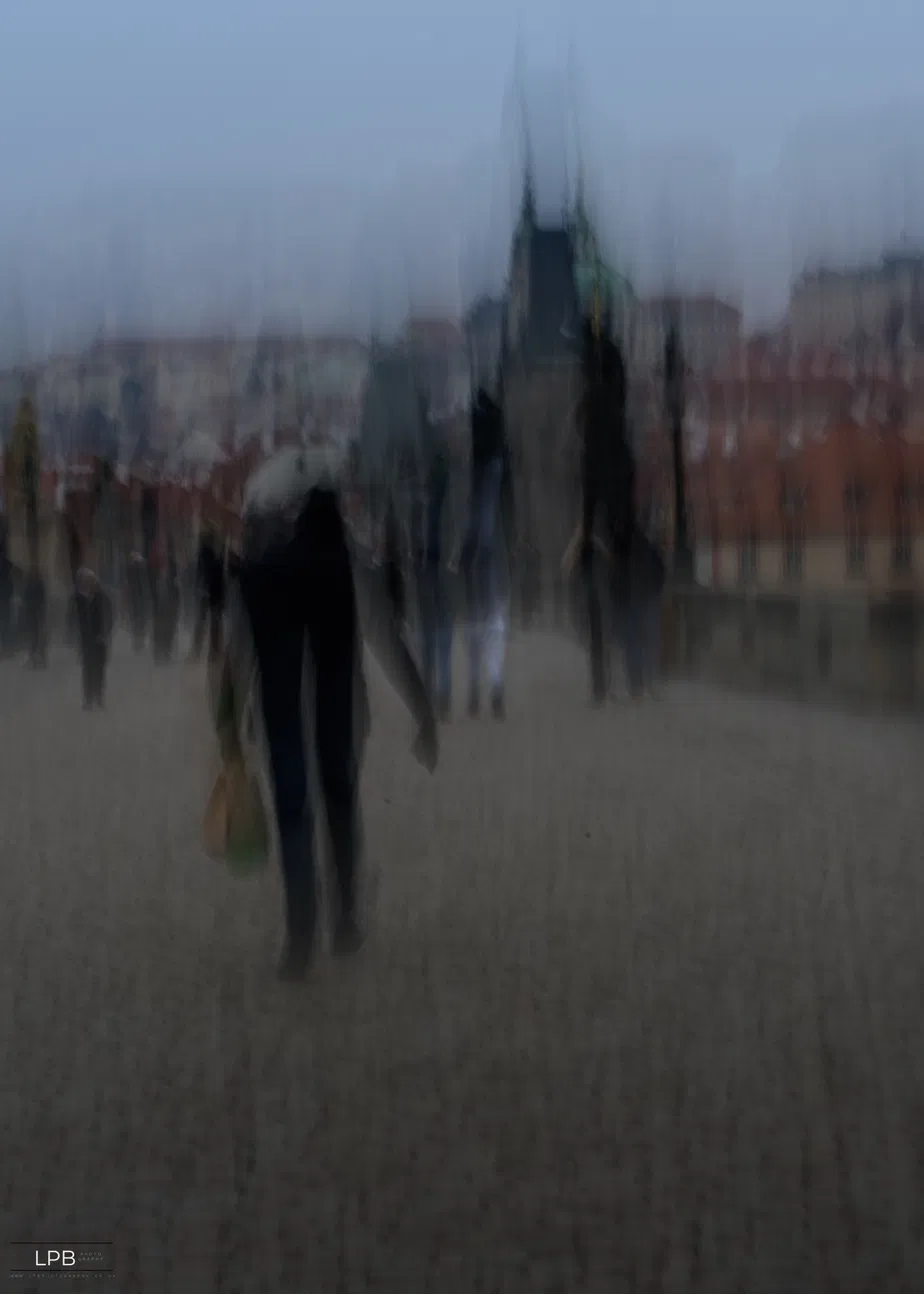A single figure under an umbrella against a smeared cityscape